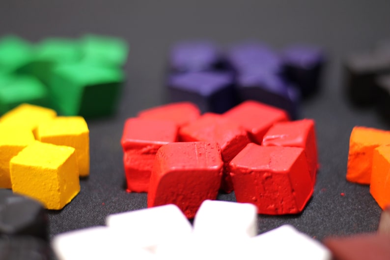 May include: A close-up of a set of colorful, geometric shaped blocks. The blocks are made of a textured material and are arranged in a circle. The colors of the blocks are red, yellow, green, blue, and white.