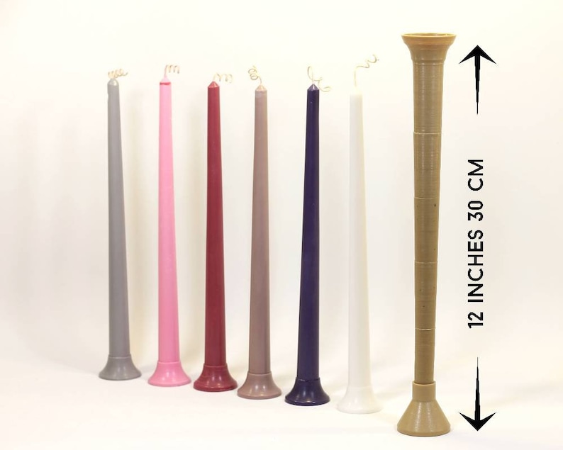 May include: Seven taper candles in various colors, including gray, pink, red, brown, purple, and white, with a gold wick. The candles are 12 inches tall and have a diameter of about 1 inch. The candles are arranged in a row on a white surface.