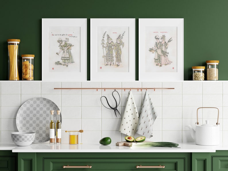 Puede incluir: Tres grabados art&iacute;sticos enmarcados con ilustraciones de figuras con vestimenta de &eacute;poca. Los grabados se exhiben sobre una encimera de cocina con varios art&iacute;culos de cocina, incluyendo frascos, un plato, un cuenco y una tetera. La cocina tiene una combinaci&oacute;n de colores verde y blanco.