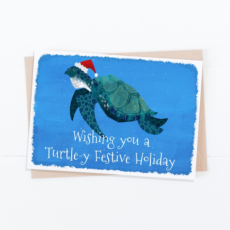 May include: A Christmas card featuring a cartoon sea turtle wearing a Santa hat, swimming in a blue ocean. The card reads "Wishing you a Turtle-y Festive Holiday."