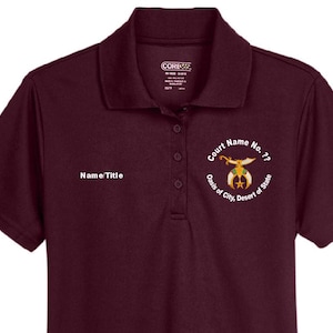 May include: A maroon polo shirt with a collared neckline and short sleeves. The shirt features the text "Name Title" on the left chest and a circular emblem with text and a graphic on the right chest. The shirt has three buttons.
