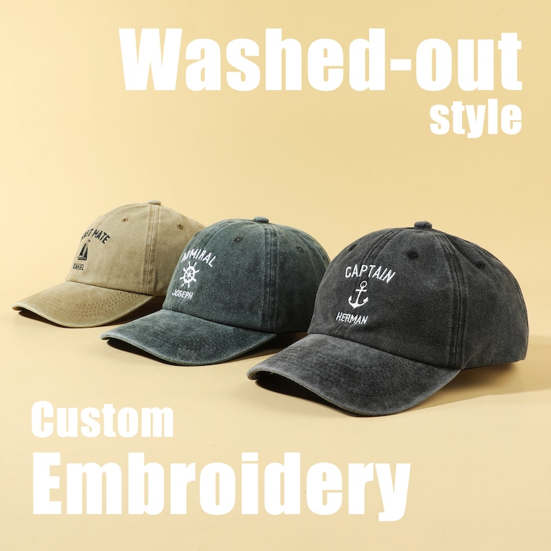May include: Three washed-out style baseball caps with custom embroidery. The caps are in different colors: beige, dark green, and black. The embroidery on the caps includes a sailboat, a ship's wheel, and an anchor.
