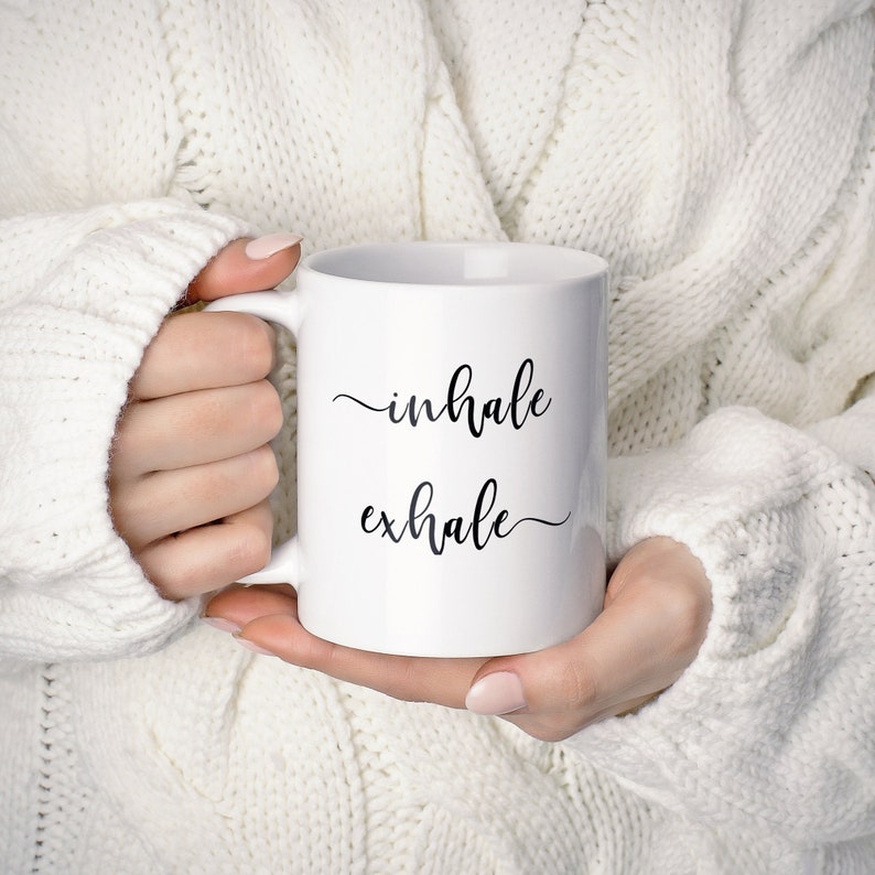 May include: White ceramic mug with black text that reads "inhale exhale" in a cursive font.