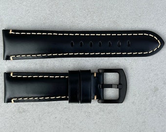 May include: Black leather watch strap with white stitching and a black buckle.