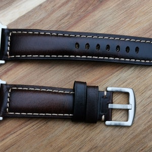 Birds eye view shot of the Berlin brown leather apple watch strap. With contrast light old stitching and a 316L stainless steel buckle.