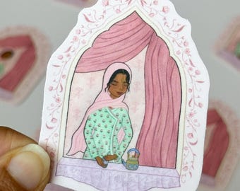 May include: A sticker featuring an illustration of a person in a pink hijab and green patterned dress, looking out a window with pink curtains. The window frame is decorated with floral designs. A small blue and gold basket sits on the windowsill.
