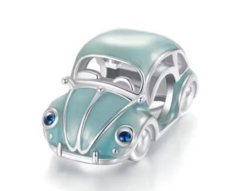 May include: A silver charm in the shape of a light blue vintage car with blue gemstone headlights.