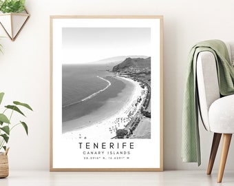 May include: Black and white aerial photograph of a beach in Tenerife, Canary Islands. The image shows a long, sandy beach with clear water and a mountain in the background. The text "Tenerife, Canary Islands 28.2316° N, 16.6291° W" is printed below the image.