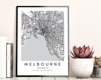 May include: Black and white map print of Melbourne, Australia with the city name and coordinates. The map is framed in a black frame and is displayed on a white surface.