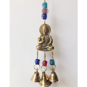 May include: Gold wind chime featuring a Buddha figurine with three bells and colorful glass beads.