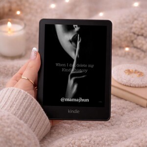 May include: A black Kindle e-reader displaying a black and white image with the text "When I die, delete my Kindle history" and the handle "@mamajhun". The Kindle is held in a hand with a gold ring.