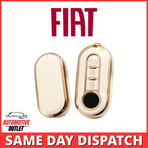 Pode incluir: Um conjunto de capas para chave de carro Fiat de formato oval com acabamento em creme e dourado. O conjunto inclui uma peça traseira de cor creme sólida e uma peça frontal com três botões dourados com ícones de porta-malas, tranca.