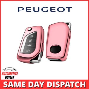 Op de afbeelding: Twee metallic roségouden autosleutelhoezen voor Peugeot-voertuigen. Eén hoes toont een zwart bedieningspaneel met vier witte iconen voor vergrendelen, ontgrendelen, kofferbak en alarm. De andere hoes toont de achterkant met een ronde uitsparing.