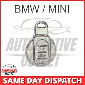 Può includere: Una chiave per auto argentata con quattro pulsanti. La chiave ha un logo BMW / MINI. La chiave è isolata su uno sfondo bianco.