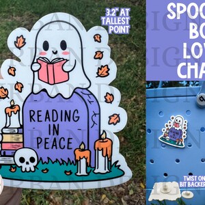 May include: A 3.2 inch tall sticker featuring a cartoon ghost reading a book on a tombstone with the text "Reading in Peace". The sticker is surrounded by fall leaves and candles. The sticker is designed to be used as a charm for a tote bag.