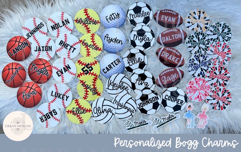 May include: A collection of personalized round sports-themed charms with various names and numbers. The charms are made of white, black, red, blue, and yellow with black lettering. The charms are arranged on a white fluffy surface. The text "Personalized Bogg Charms" is at the bottom of the image.