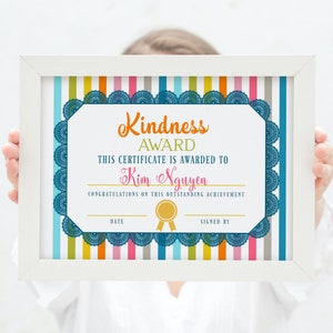 May include: A white framed certificate with the words "Kindness Award" in orange script. The certificate is awarded to Kim Nguyen and has a blue scalloped border. The background has vertical stripes of various colors.