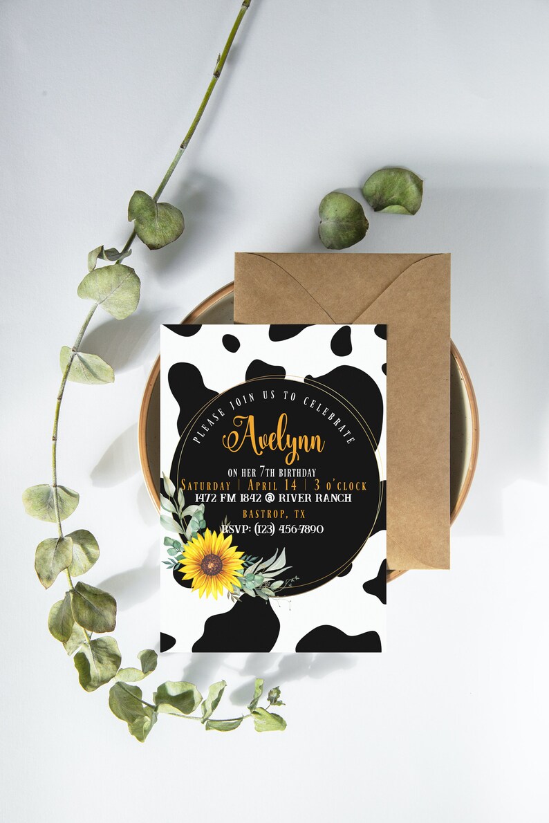 May include: A birthday invitation with a cow print background and a gold-rimmed circle. The circle contains the name "Avelynn" in gold script, along with event details and a sunflower illustration. A brown envelope is included.