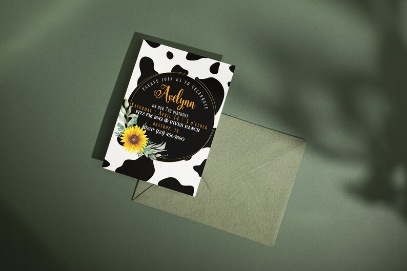 May include: A birthday invitation with a cow print background and a black circle with gold text that reads "Avelynn". The invitation includes a sunflower and greenery. An envelope is next to the invitation.