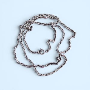 Peut inclure: Un collier en chaîne métallique de couleur argentée composé de maillons ovales allongés reliés en une série continue. La chaîne comprend un petit fermoir à ressort circulaire qui permet d'ouvrir et de fermer le collier en toute sécurité.