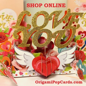 May include: A 3D pop-up card with a red heart with white wings and the words "LOVE YOU" in gold glitter letters. The card is decorated with red roses, hearts, and other floral elements. The card reads "OrigamiPopCards.com" at the bottom.