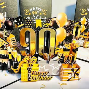 Tarjeta de felicitación emergente "Feliz cumpleaños número 90" con regalos, pasteles y globos. Hecha a mano con amor. Compra en línea: https://origamipopcards.com/