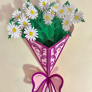 Blumenstrauß aus weißem Gänseblümchen, eingewickelt in lila Band