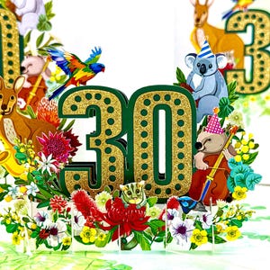 May include: A pop-up birthday card with the number "30" in green with gold glitter detailing. The card is decorated with Australian animals, flowers, and a rainbow lorikeet. The animals include a kangaroo, koala, and wombat.