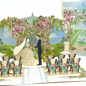 May include: A pop-up wedding card featuring a bride and groom under a floral archway. The scene includes chairs with floral decorations, a blue aisle runner, and a garden backdrop with a fountain. The card is a 3D design.