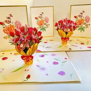 May include: Three pop-up cards with a bouquet of red, pink, and white flowers in a yellow paper wrapper with a red bow. The cards are open and the flowers are in 3D.