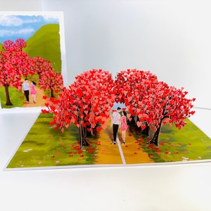 Tarjeta de felicitación 3D emergente con un bosque de cerezos en flor y una pareja enamorada. ¡Feliz aniversario! COMPRA en línea: https://origamipopcards.com/