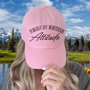Peut inclure: Casquette de baseball rose clair avec l'inscription "FORGIVE MY NORTHERN Attitude" en script noir. La casquette a une visière incurvée et une fermeture à sangle. Un accessoire de mode décontracté.