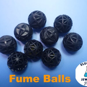 May include: A collection of black fume balls with a geometric design, arranged on a light blue surface. The text "Fume Balls" is displayed in orange. The image also includes a logo for "Electro Jeweler Jordan."