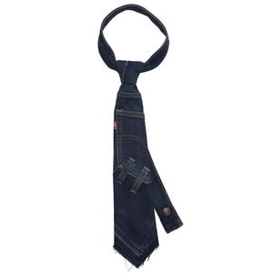 K&ouml;nnte beinhalten: Eine dunkelblaue Jeans-Krawatte mit einzigartigem Design. Die Krawatte scheint aus recycelten Jeans gefertigt zu sein, mit Taschen-Details und einem Knopfverschluss. Das rote Levi's-Etikett ist sichtbar.