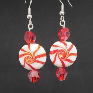 May include: Red and white candy cane swirl glass bead earrings with red crystal accents.