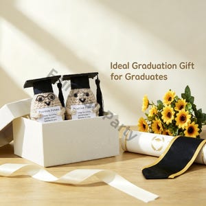 May include: Two crocheted potato figures wearing graduation caps are in a white gift box. Each potato holds a sign that reads "Positive Potato." A bouquet of sunflowers and a diploma with a black ribbon are also in the image. The text "Ideal Graduation Gift for Graduates" is visible.
