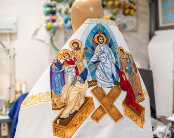 Könnte beinhalten: Weißer Stoff mit einem gestickten Bild von Jesus Christus, der in den Himmel auffährt, umgeben von Figuren von Heiligen und Engeln. Das Bild ist im traditionellen byzantinischen Stil gehalten, mit goldenen Akzenten und leuchtenden Farben. Der Stoff ist wahrscheinlich für die Verwendung als religiöses Kleidungsstück oder Altartuch bestimmt.