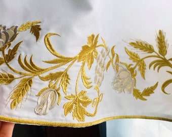 May include: White fabric with gold and white embroidered floral design. The design features roses, wheat, and leaves.