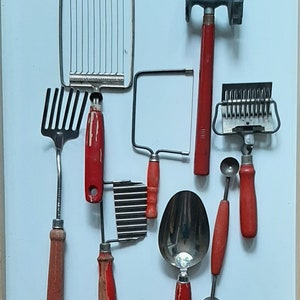 May include: A set of eight vintage kitchen tools with red handles. The tools include a potato masher, a fork, a grater, a cookie cutter, a pastry cutter, a melon baller, a pastry brush, and a pie server.