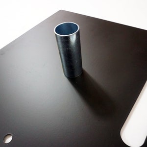 May include: Black metal square base with a silver metal pipe in the center. The base has a rectangular cutout on the right side.