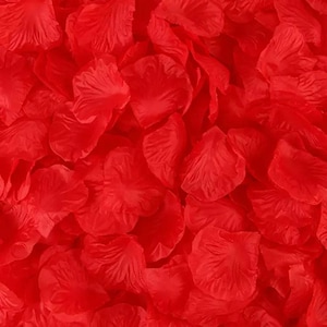 May include: A close-up shot of a pile of bright red artificial rose petals. The petals are layered and textured, creating a full and vibrant display. The petals are a solid, saturated red color.