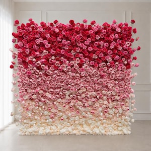 May include: A large rectangular floral wall backdrop composed of numerous roses arranged in a vertical ombre gradient. The colors transition from deep crimson and dark red at the top, through shades of bright pink, to light pink and white at the base.