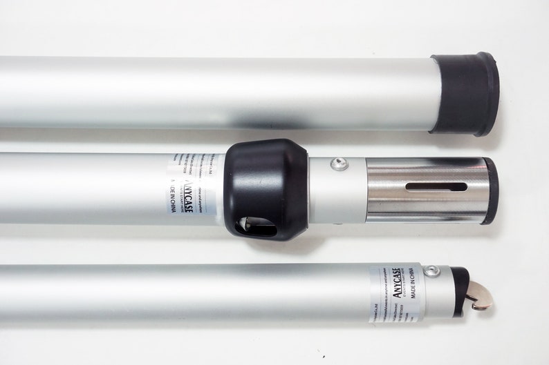 May include: Three silver telescoping poles with black end caps. The middle pole has a silver connector with a black cap and a label that reads "ANYCASE MADE IN CHINA".