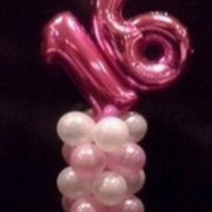 Könnte beinhalten: Ein rosa und weißer Ballon-Mittelpunkt mit der Zahl 16 in rosa Ballons.