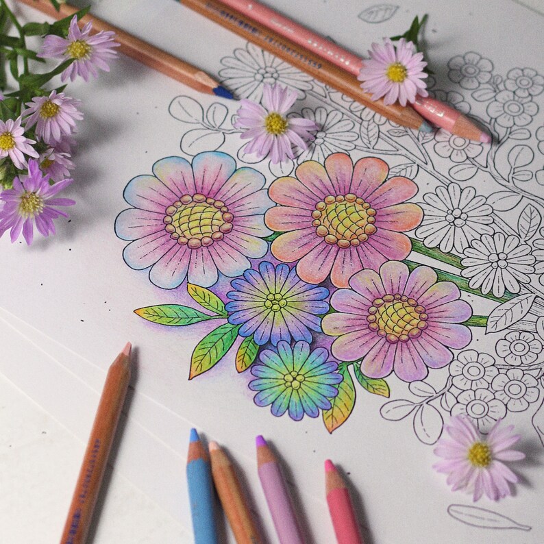 May include: A coloring book page with a bouquet of colorful flowers. The flowers are pink, purple, and blue. The page is surrounded by pencils.