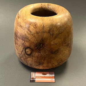Puede incluir: Un tazón de madera grande y redondo con un acabado de madera natural. El tazón tiene una abertura ancha y una superficie lisa y pulida. La veta de la madera es visible y tiene un patrón único. El tazón está hecho por Hand View Woodcraft, Nick Murphy.