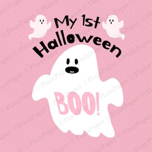 K&ouml;nnte beinhalten: Eine rosa Grafik mit dem Text "My 1st Halloween" und einer wei&szlig;en Geisterillustration. Der Geist hat einen schwarzen Mund und Augen, mit dem Wort "BOO!" in Rosa. Zwei kleinere Geisterillustrationen sind ebenfalls vorhanden.