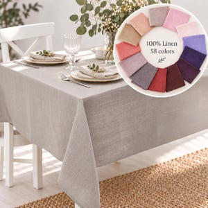 Puede incluir: Un mantel de lino gris claro cubre una mesa de comedor con platos, servilletas y cristalería. Un círculo insertado muestra muestras de tela en varios tonos con el texto 100% Linen 58 colors y una pequeña ilustración de hoja.