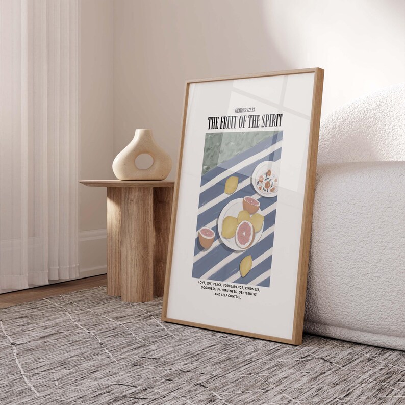 K&ouml;nnte beinhalten: Ein gerahmter Druck mit einem blau-wei&szlig; gestreiften Hintergrund und einem Teller mit Zitrusfr&uuml;chten. Der Text "GALATIANS 5:22 THE FRUIT OF THE SPIRIT" befindet sich oben auf dem Druck. Der Text unter den Fr&uuml;chten lautet: "LOVE, JOY, PEACE, FORBEARANCE, KINDNESS, GOODNESS, FAITHFULNESS, GENTLENESS, AND SELF-CONTROL."