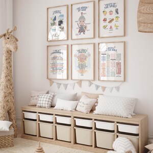 May include: A set of six framed prints with colorful illustrations and text about the Bible. The prints are hung on a white wall in a nursery with a wooden storage bench and pillows.